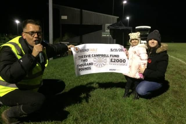 Alnwick Round Table presents the cheque to Evie and Rebecca Campbell at the fireworks night.