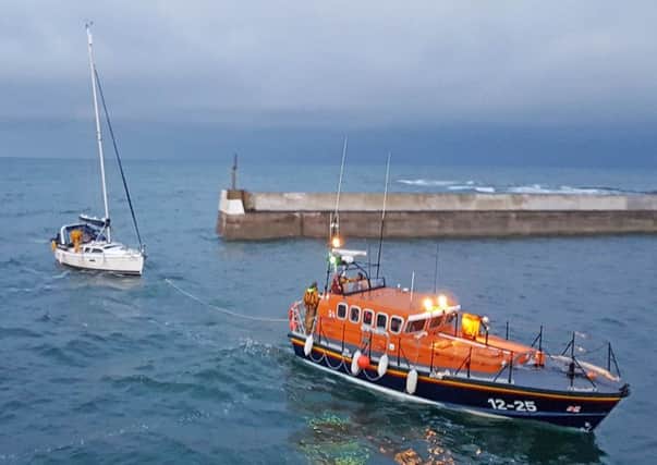 The yacht being towed by Seahouses RNLI.