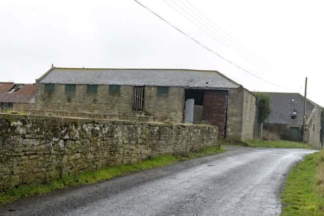 The narrow Gloster Hill Road running past the farm buildings, which are set to be replaced.