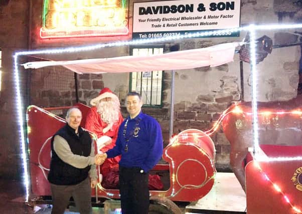 Santa visited Davidson's Electricals of Alnwick to thank them for all their help over the years with lighting up his Sleigh each Christmas. Picture left to right Kevin Nicholson from Davidson's, Santa Claus and Alnwick Lions Club President John Hughes.
