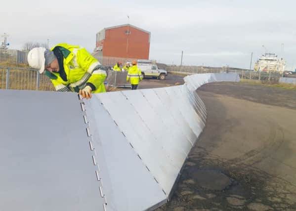 Environment Agency workers erect the temporary barrier at Blyth as the region prepares for a coastal surge. Picture by Jane Coltman