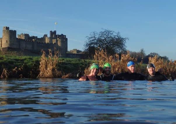 Jane Hardy,  Richard Canterbury and two members of the wedding party in the River Aln, with Alnwick Castle in the background.