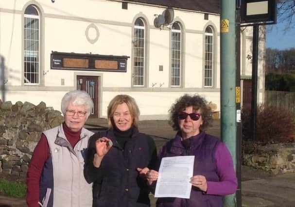 Representatives of Belford's Hidden History Museum with the token outside the former site of the Scotch Church.