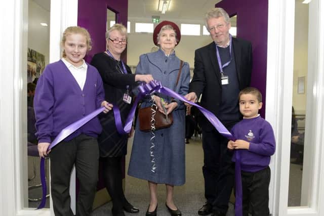 Peggy Stanton cuts the ribbon watched by headteacher Jenny Smith, chair of governors Bill Grisdale, the oldest pupil Maddison McKay and the youngest pupil Omer Unsal at the official opening of the new extension at Swansfield Primary First School.
 Picture by Jane Coltman