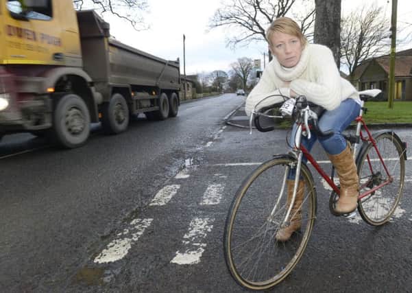 Councillor Kate Cairns standing with her bicycle in Longhoughton.
 Picture by Jane Coltman
