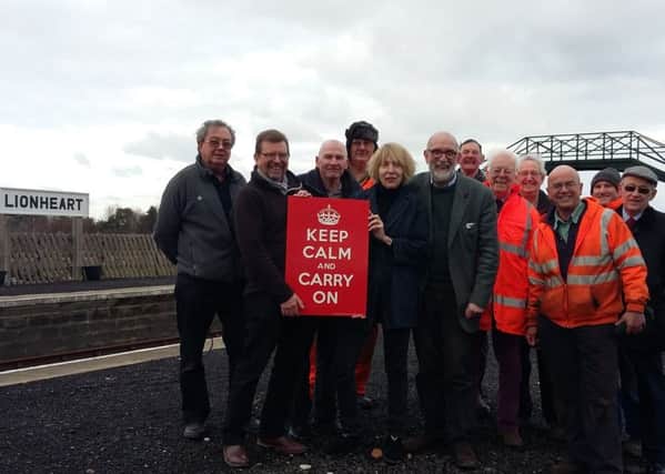 Mary and Stuart Manley present the Keep Calm and Carry On sign to members of the Aln Valley Railway.