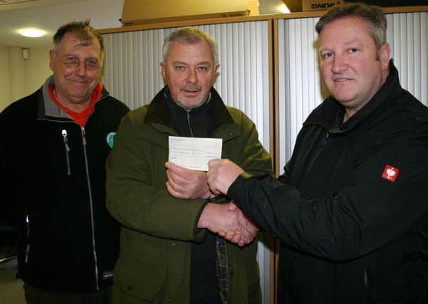 From left: Paul Morrison, Warkworth Harbour Commissioner; Les Weller, Amble Sea Angling Club; and Simon Baxter, Harbour Master, with the cheque for Â£300, raised after the fire on Amble pier.