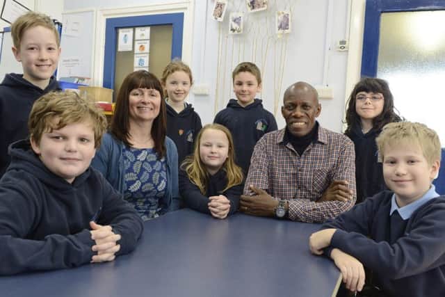 Moses Kiwala from Children's Sure House in Uganda with Ellingham First School headteacher Diane Lakey and some of the pupils during his visit.
 Picture by Jane Coltman