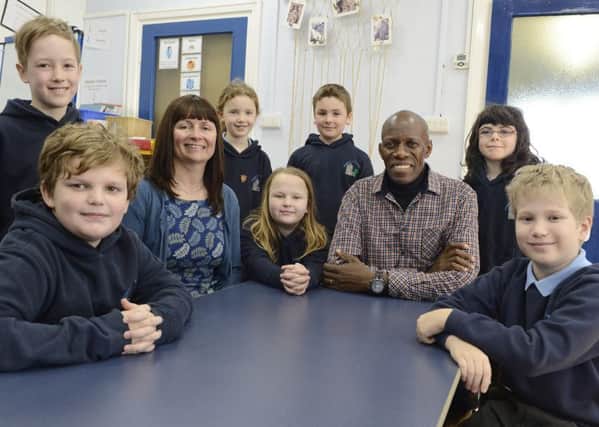 Moses Kiwala from Children's Sure House in Uganda with Ellingham First School headteacher Diane Lakey and some of the pupils during his visit.
 Picture by Jane Coltman