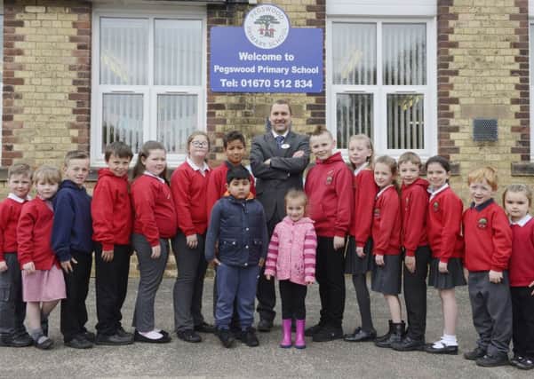 Pegswood Primary School headteacher Andrew Waterfield and some of his pupils who are delighted with their Ofsted report.
 Picture by Jane Coltman