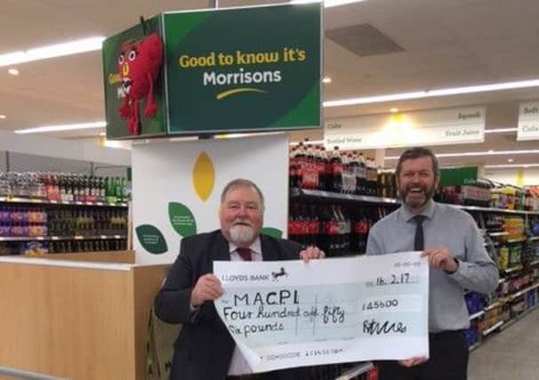 Morrisons manager, Dave Beaney, right, presents a cheque to the chairman of MACPI, the Hon David Archer.