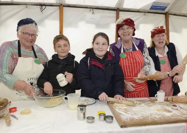 Roddam WI members making girdle scones with Ellingham school pupils at the Children's Countryside Day at Wooler.
 Picture by Jane Coltman