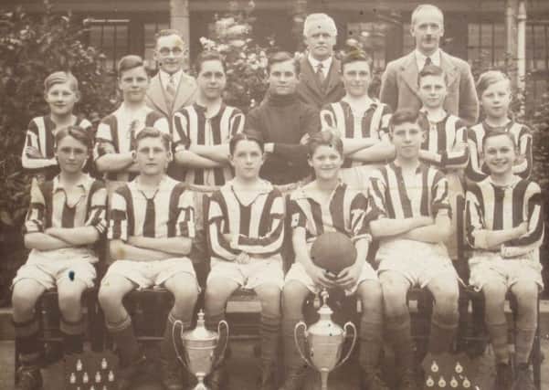 Wallsend's Stephenson Memorial School under-15s football team with numerous trophies they won in football competitions in 1936-37. One is the Blake Cup.
