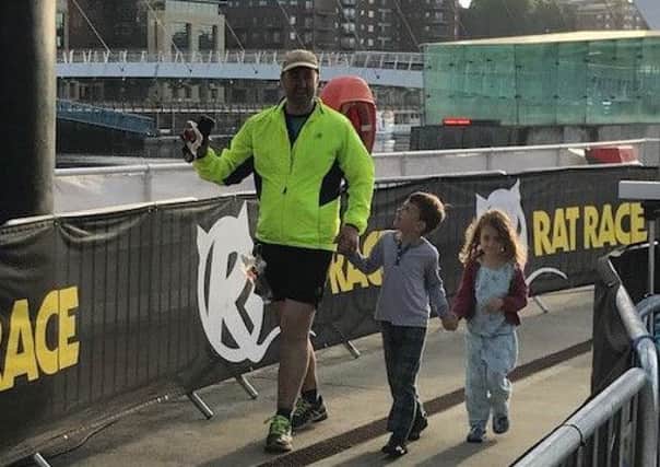 Andrew Wilson crossing the finish line with his children Michael and Juliet just after 6am.
