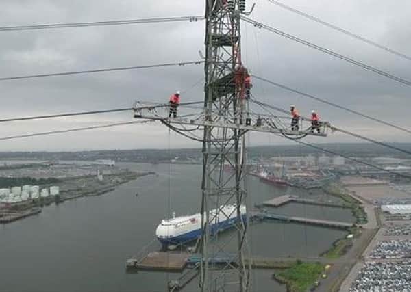 Engineers from the National Grid working on raising pylon wires over the river Tyne.