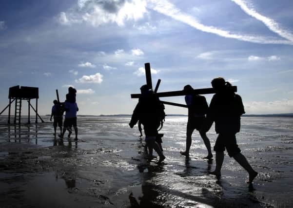 Christian pilgrims carry crosses along the causeway to Holy Island  as they take part in the Northern Cross pilgrimage to Lindisfarne.