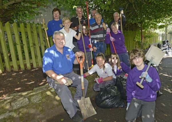 Members of Alnwick Lions with Jenny Smith and pupils from Swansfield Park Primary school at the path they are clearing. Picture by Jane Coltman