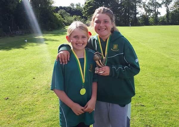 Rebecca and Ellie Allan with their cricket medals.