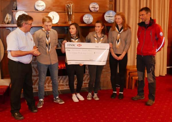 Northumberland National Park Mountain Rescue Team leader Iain Nixon
receives a cheque from Rothbury Explorer Scouts.