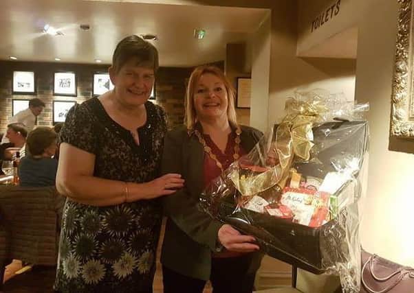 Amble Mayor Jane Dargue, right, is presented with the hamper to Amble Food Bank by raffle winner Allison Hills.