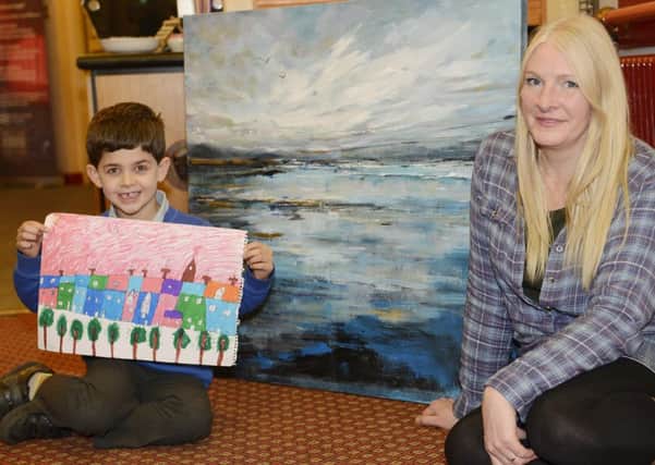Max Kearns and Nicola Stevenson with their Alnmouth Arts Festival poster entries.
 Picture by Jane Coltman