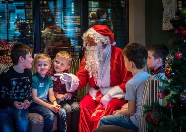 Santa Claus meets some of the school children.