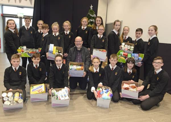 Students from Years 7 to 9 at the Duchess's Community High School hand over their food parcels to Peter Sutcliffe from Alnwick and District Food Bank. Picture by Jane Coltman