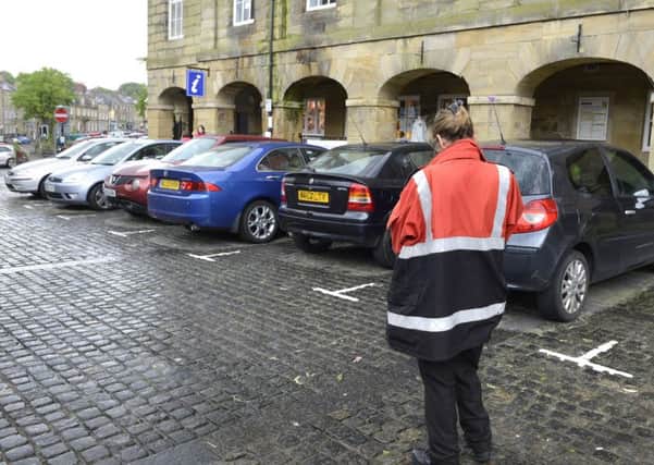 A Community Enforcement Officer checks the cars parked in Alnwick Market Place. Picture Jane Coltman