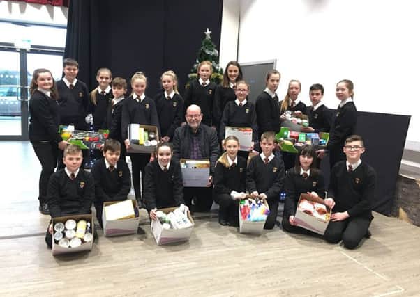 Duchess's Communty High School pupils handing over donations to Alnwick District Food Bank trustee Peter Sutcliffe.