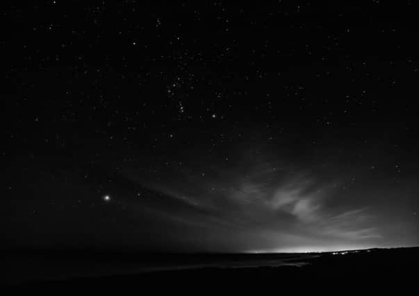 Lights in the starry night sky looking down the coast towards Coquet Island. Picture by Ivor Rackham.