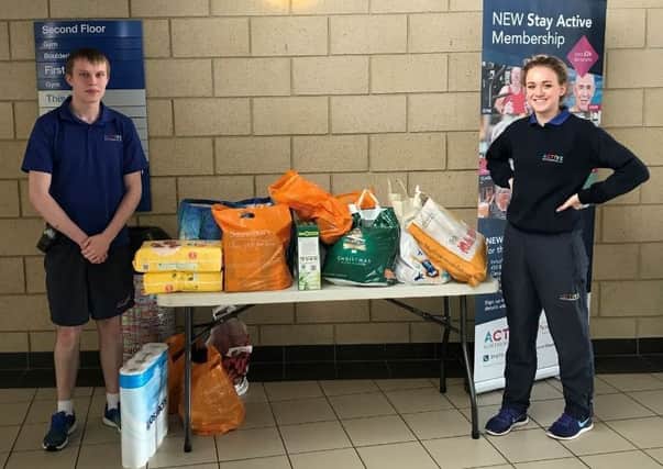 Callum ONeill and Amy Thorne, leisure assistants at Alnwick's Willowburn Sports and Leisure Centre, with food donations collected at the charity yoga event.