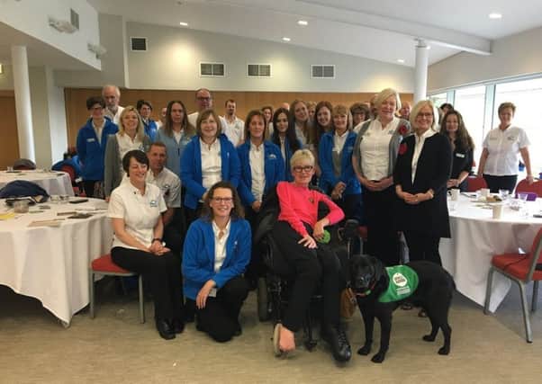 Barking Mad franchisees, including Tina Young, seated left. Labrador Christa gave a demonstration of her skills as a Dogs For Good ambassador.