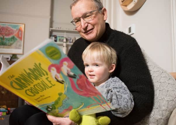 Jonnie Wild reading his new book, The Carnivorous Crocodile, to his grandson Rory.