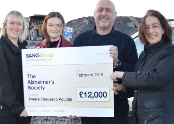 Lucy King, of The Alzheimer's Society, second left, receiving the money from Michelle Cairns, Neil Cook and Catherine Fabi, of The Banks Group at the firm's Shotton surface mine.