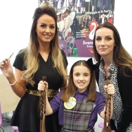 Evie Cross, middle, holds her chopped-off hair. She is joined by her mum Kelly, right, and hairdresser Becca Allan, from Alnwick's Bex Hair and Beauty Boutique.