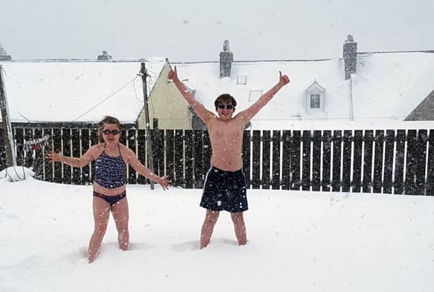 They're a hardy bunch in Rothbury. Elliott Fox, 13, and Lacey Taylor, nine, 'swimming' in the snow. Picture by Kerry Boyle