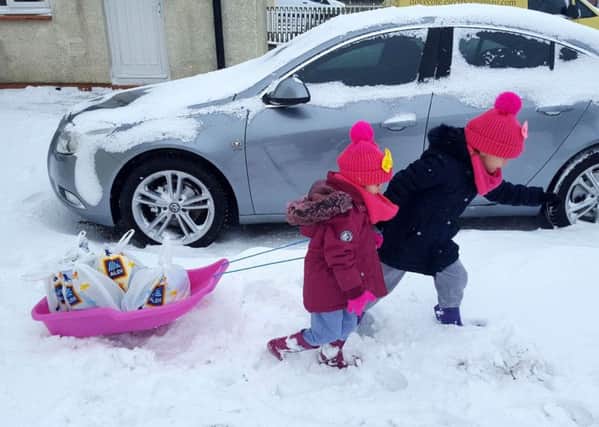 Sisters Sophie and Paige Tait haul their sledge of supplies through the snow in Shilbottle.