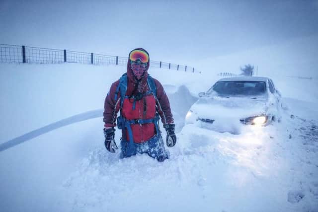 Team Medical Officer Jamie Pattison in the snow with a stranded vehicle.