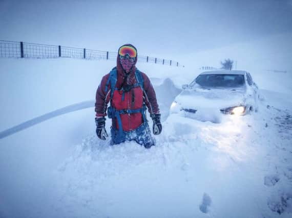 Team Medical Officer Jamie Pattison in the snow with a stranded vehicle.