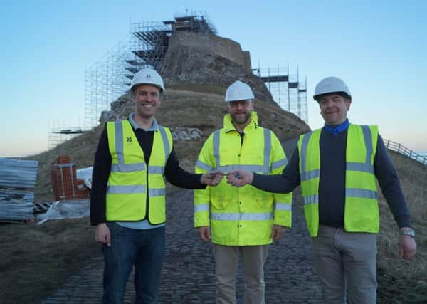Lindisfarne Castle house steward Nick Lewis, left, is given back the keys to the castle by Dave Hepton, middle, and Phil Robson, right, from contractors Datim. Picture by National Trust