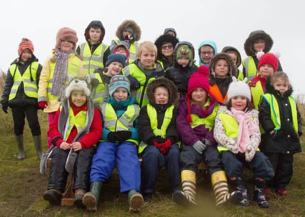 Pupils from Lowick and Holy Island schools at the new seat which will provide a resting place for walkers at the end of Pilgrim's Way.