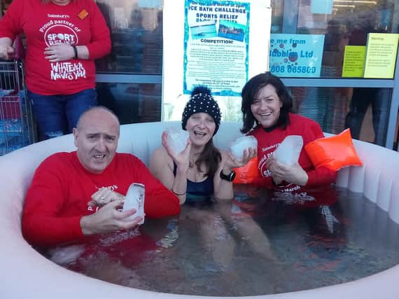 Gerry Storey, Jane Hardy and Anita McDonald in the pool of freezing water outside Sainsbury's Alnwick.