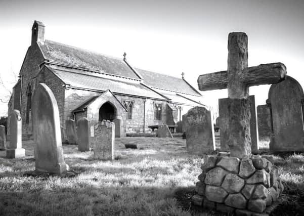 An atmospheric shot of a church and gravestones, by Jimmy Morse.