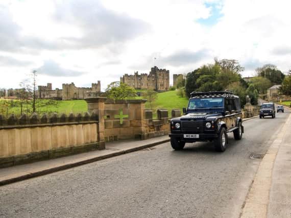The convoy of Land Rovers crosses the Lion Bridge in Alnwick. Picture by Andy Cowan