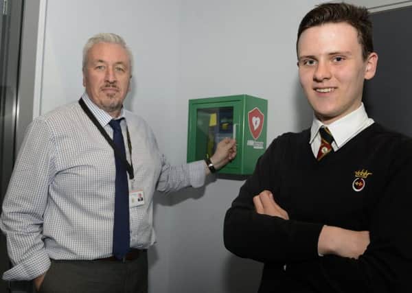 Max Young with the defibrilator and Health and Safety Co-ordinator Craig Watson at the Duchess's Community High School. Picture by Jane Coltman