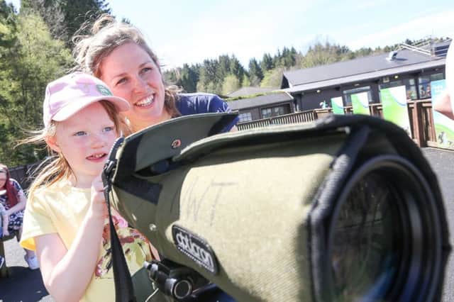 Kielder osprey assistant Ellie Kent shows a youngster how to use one of the osprey watch scopes. Picture by Neil Denham