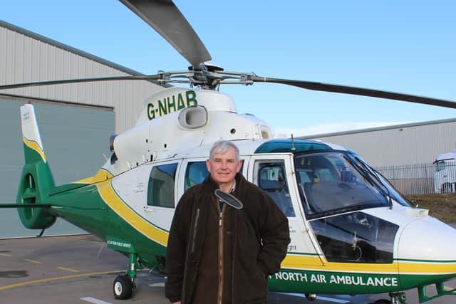 Simon Orpwood with the GNAAS ambulance which helped rescue him last year.