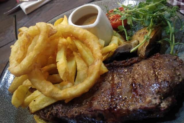 Sirloin steak with chips, onion rings, tomato and mushroom with a peppercorn sauce.